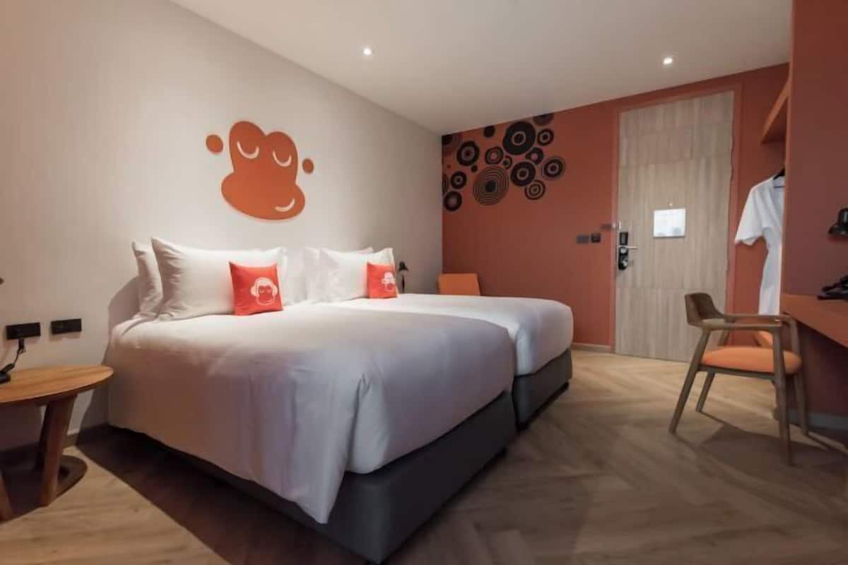 Une chambre d’hôtel moderne avec un grand lit, un bureau et une chaise.