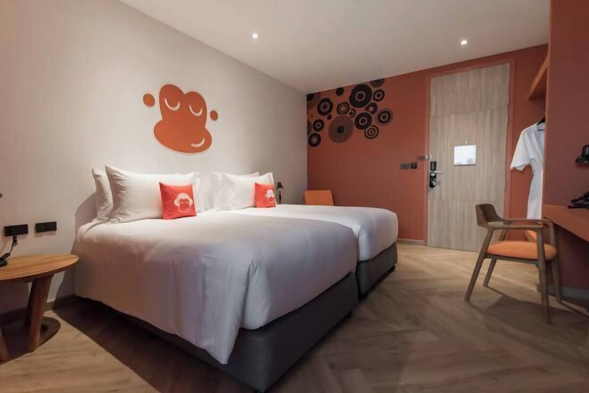 Ein modernes Hotelzimmer mit einem großen Bett, einem Schreibtisch und einem Sessel.