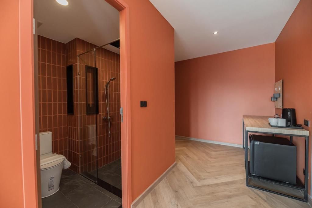A compact bathroom with a shower, toilet, and a small sink area.