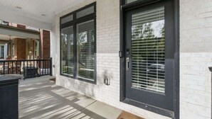 A modern building with large windows and a black door. - Luxury Columbus Townhouse with Game Room & Patio (Columbus)