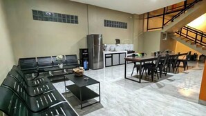 Una cocina moderna con comedor, un conjunto de sofás y una escalera.