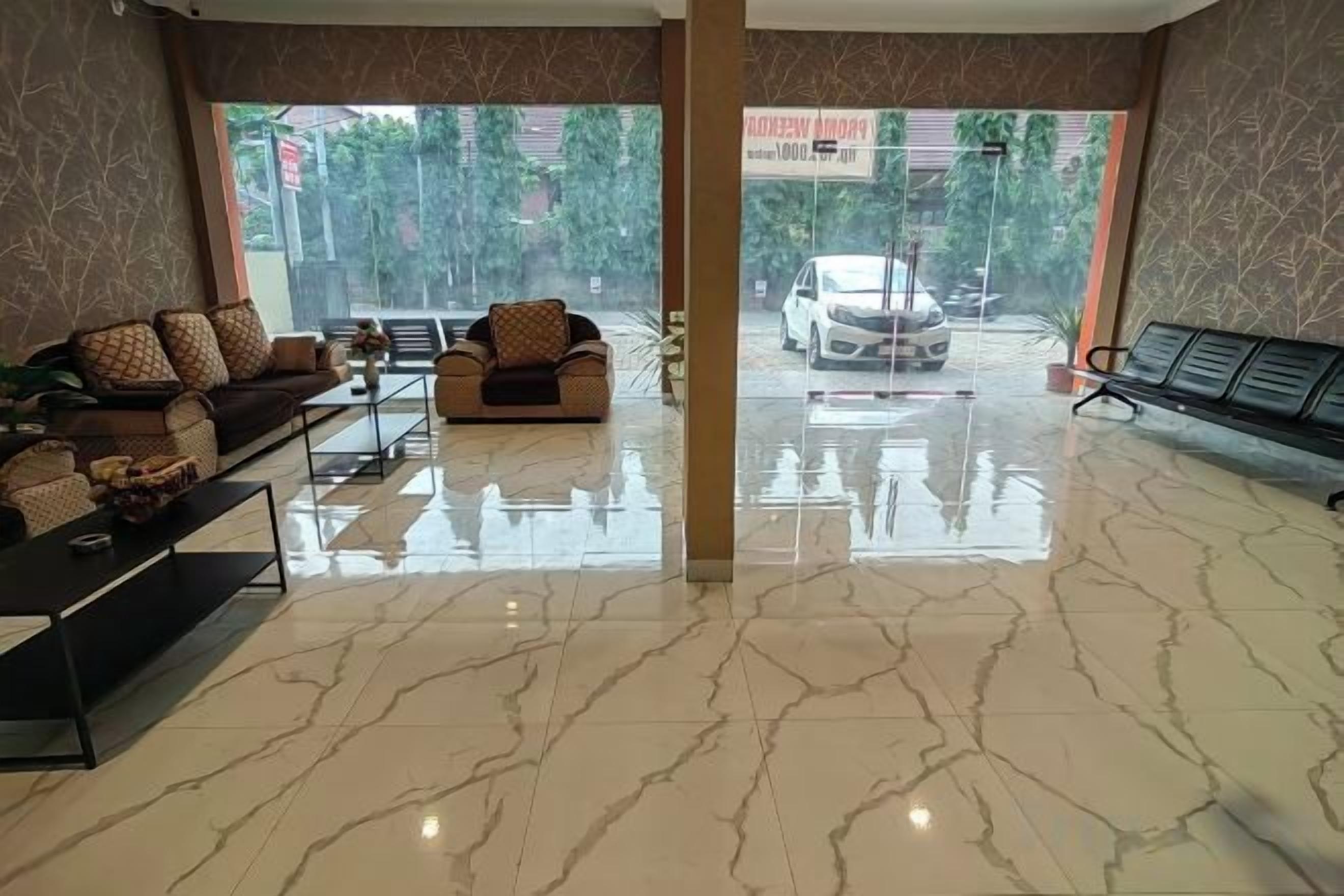 A hotel lobby with a marble floor, sofas, a coffee table, and a view of the street.