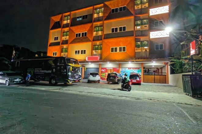 Un edificio de varios pisos con una zona de estacionamiento al frente.