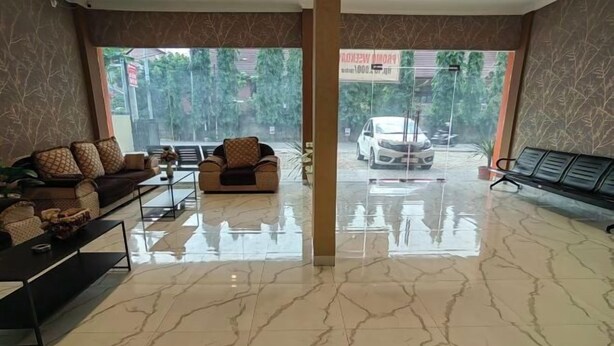 Un hall amplio con suelo de mármol, un conjunto de sofás, una mesita de café y un banco.