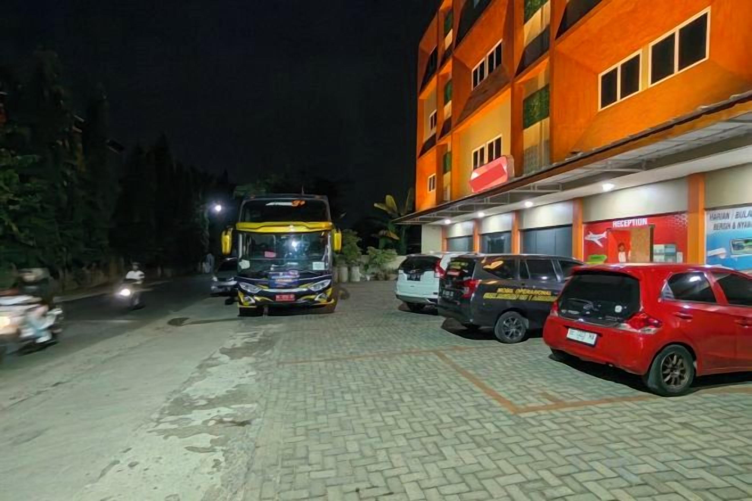 Ein Gebäude mit einer Rezeption, einem abgestellten Bus und mehreren Autos.