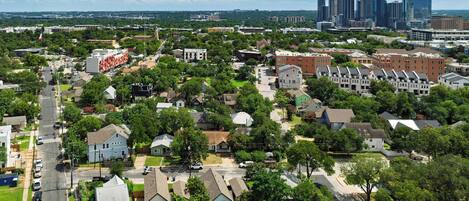 A residential area with houses, streets, and a distant city skyline.