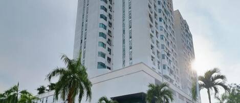 A high-rise building with multiple floors, surrounded by palm trees.