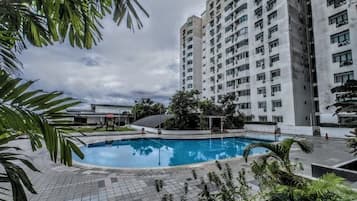 A swimming pool surrounded by a high-rise building with multiple balconies.