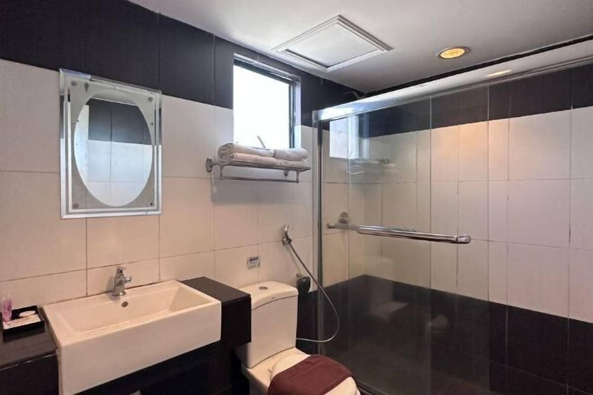 Une salle de bain équipée d’un lavabo, de toilettes et d’une douche à parois en verre.
