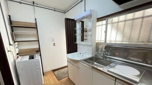 Una cocina compacta con horno integrado, un fregadero y una ventana con vistas.