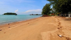 A beach with a sandy shore, a small island in the distance, and a boat. - PD D'Wharf Premium Suite - Full Seaview (Up to 6 Pax) (Port Dickson)
