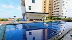 A swimming pool with a clear view of the surrounding buildings and a lifeguard chair. - PD D'Wharf Premium Suite - Full Seaview (Up to 6 Pax) (Port Dickson)