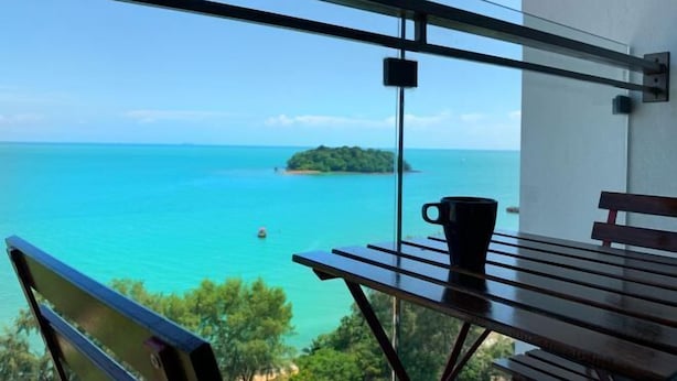 A balcony with a view of the sea, a wooden table, and a bench. - PD D'Wharf Premium Suite - Full Seaview (Up to 6 Pax) (Port Dickson)