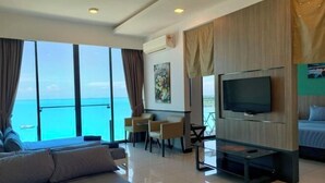 A modern hotel room with a large bed, a TV, a desk, and a balcony with a view of the ocean. - PD D'Wharf Premium Suite - Full Seaview (Up to 6 Pax) (Port Dickson)