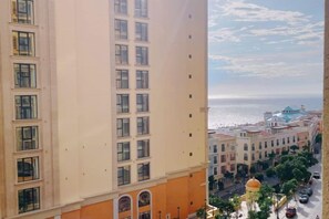 A high-rise building with multiple floors and a view of the sea in the background.
