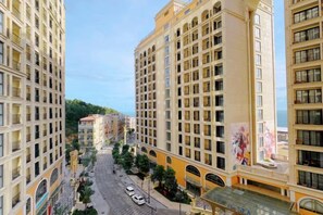 Un hotel de varios pisos con un patio central, balcones y vista a la calle.