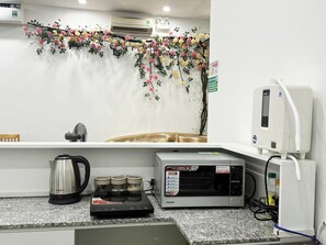 A kitchen with a coffee maker, a toaster, and a microwave.