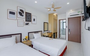 A hotel room with two beds, a desk, a mirror, and a ceiling fan. - Lalisa Hotel (Phu Quoc)