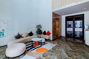 A modern living room with a sofa, a small table, and a potted plant.