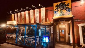 Un restaurant japonais traditionnel, reconnaissable à sa façade bleue et à son enseigne en japonais.