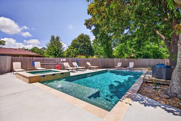 A rectangular swimming pool with a wooden deck, surrounded by lounge chairs and a wooden fence. - POOL HOT TUB! Entertainment & Location- Something for Everyone! (Long Beach)