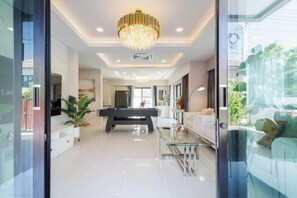 A modern interior with a billiards table, a glass coffee table, and a chandelier. - Pattaya detached four-bedroom five-bed room pool villa (Pattaya)