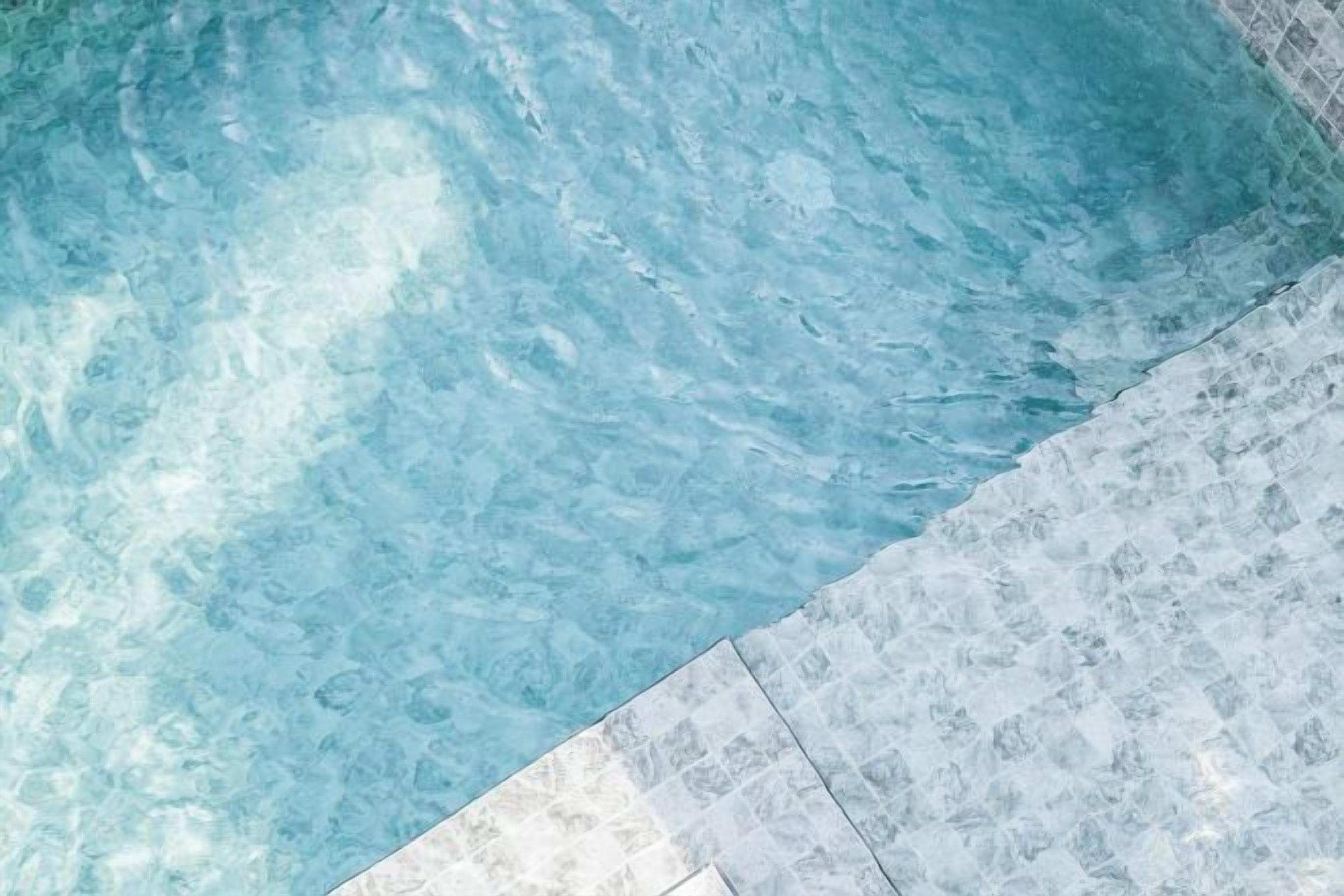 Vista despejada de una piscina con borde de azulejos.