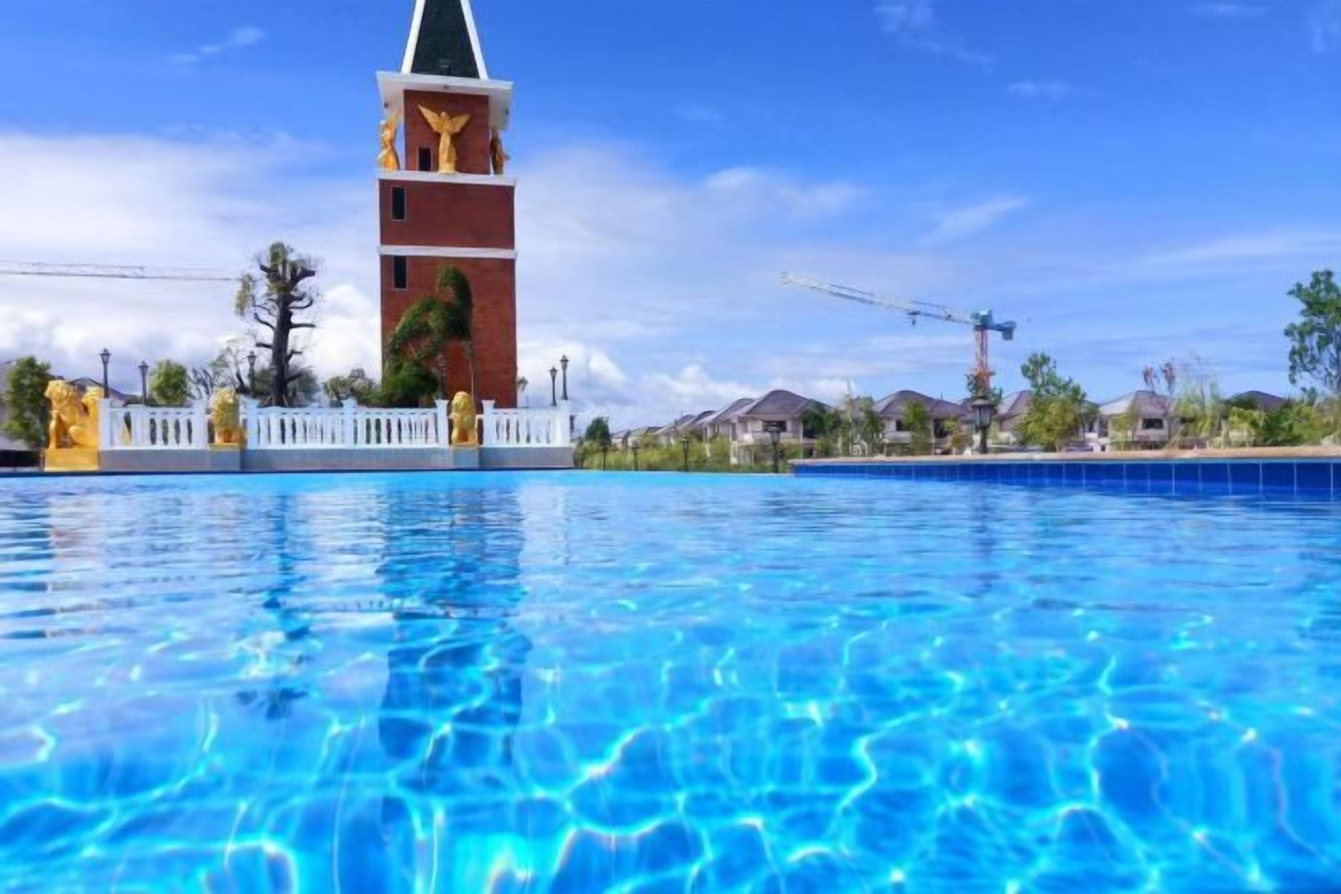 Una piscina con una estructura de torre al fondo.
