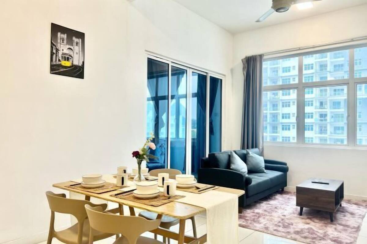 A modern living room with a dining area, a sofa, and a large window with a view of buildings.
