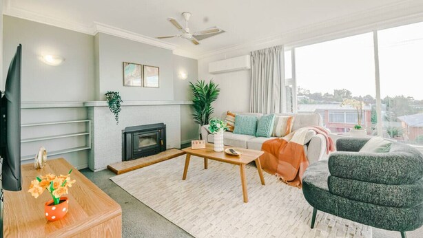 Una sala de estar moderna con chimenea, un sofá, una mesa de centro y un televisor.