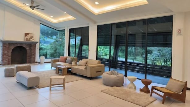 Un salón amplio con chimenea, ventanas grandes y muebles modernos.