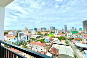 Vista panorámica de la ciudad desde un balcón, con edificios y cielo despejado.