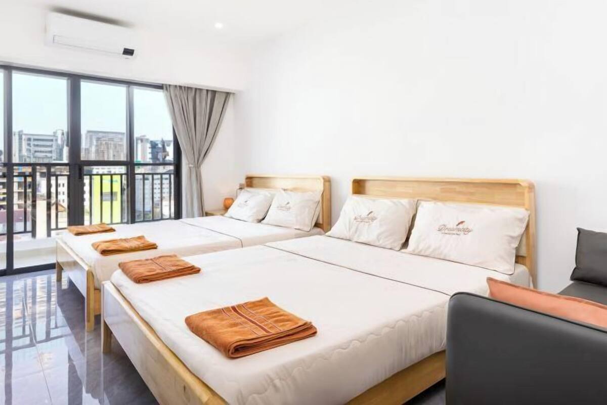 Habitación de hotel con dos camas, vistas a la ciudad y un balcón.