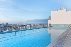 Une piscine à débordement située sur le toit, offrant une vue panoramique sur la ville.
