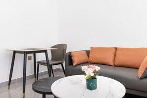 Un salon moderne avec un canapé, une table basse et un fauteuil.