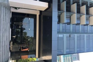 A modern building with a glass facade, large windows, and a balcony with white railings. - Andromeda Condominium Seaview Amazing Room (Pattaya)