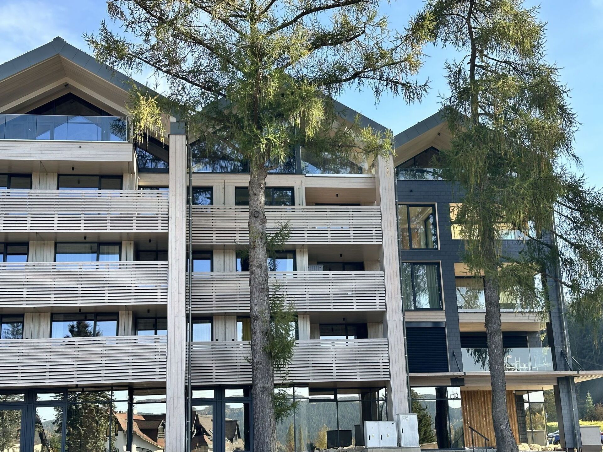 Un immeuble à plusieurs étages doté d’une architecture moderne, avec des balcons et de grandes fenêtres.