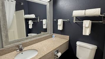 A bathroom with a sink, mirror, toilet, and towel rack.