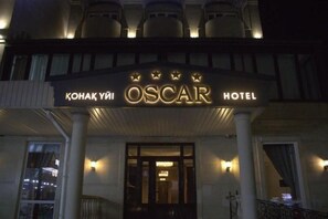 Exterior do Hotel Oscar com toldo, colunas e varanda.