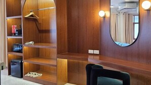 A modern room with wooden shelving, a mirror, and a black chair. - Yaowarat Stay (Bangkok)