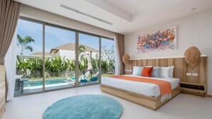 A bedroom with a large bed, a view of a swimming pool, and a tropical garden outside the window. - Two Flamingo Villa 2 (Phuket)