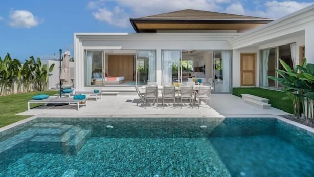 A modern house with a swimming pool, outdoor seating, and a well-maintained lawn. - Two Flamingo Villa 2 (Phuket)