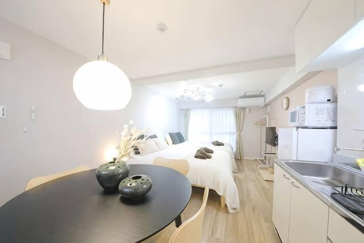 A modern kitchen with a dining table, a refrigerator, and a sink.