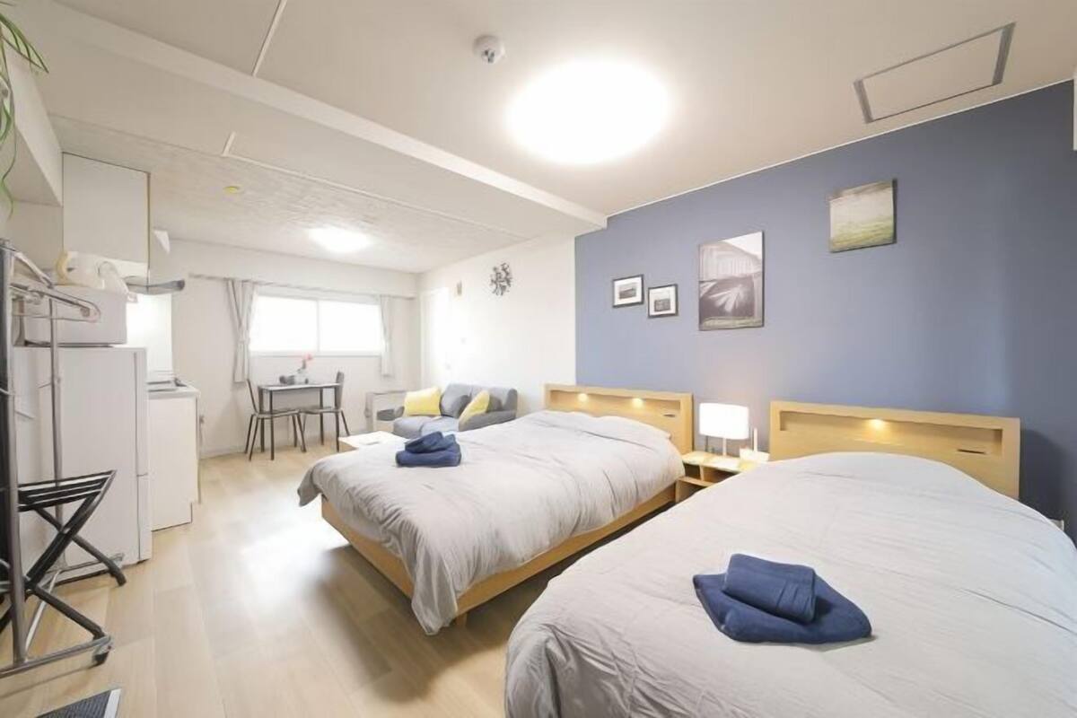 A hotel room with two beds, a desk, and a chair.