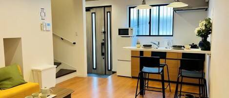 Una sala de estar moderna con un sofá, una mesa de centro y una cocina con una mesa de comedor y sillas.