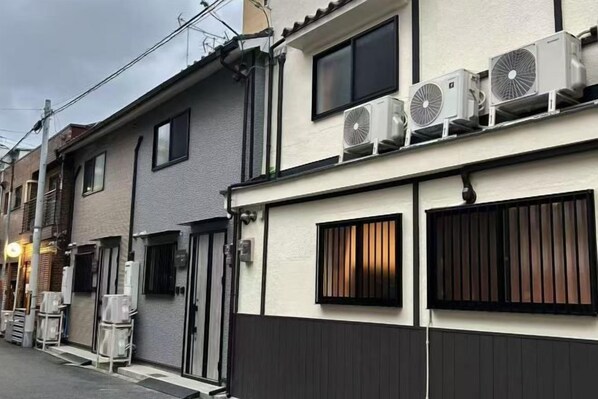 A row of residential buildings with air conditioning units mounted on the exterior walls. - ASOBO OSAKA Kuromon 3rd (Osaka)
