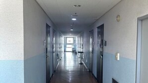 A long, narrow hallway with doors on both sides, leading to a bright room at the end. - HaiLun Officetel (Seoul)