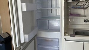 A kitchen with white cabinets, a microwave, and a small countertop with a sink and some items. - HaiLun Officetel (Seoul)