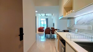 A modern kitchen with a marble countertop, a built-in oven, and a ceiling fan. - Bay Win La.mer Butik (Kota Kinabalu)
