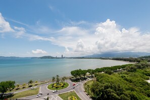 A coastal road with a roundabout, palm trees, and a view of the sea and distant mountains. - Bay Win La.mer Butik (Kota Kinabalu)